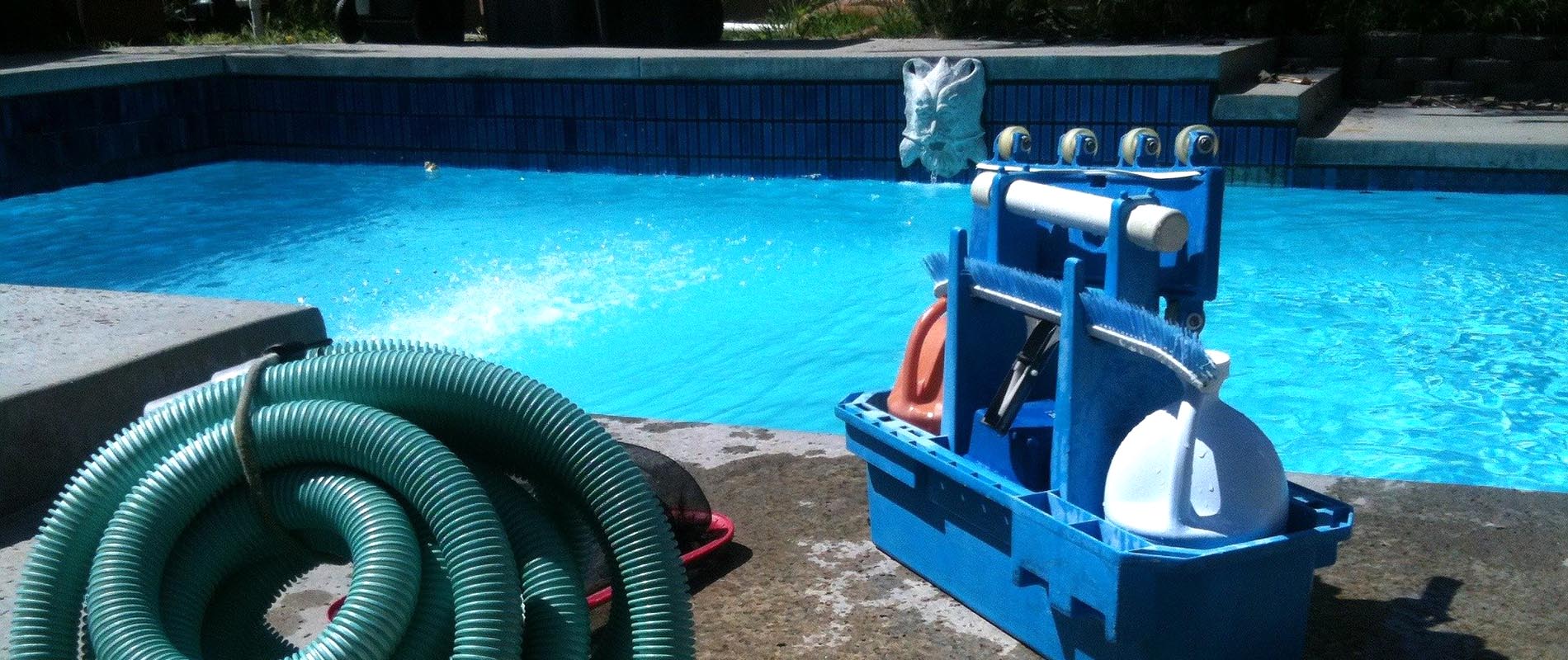 Equipo de limpieza de piscinas junto al agua